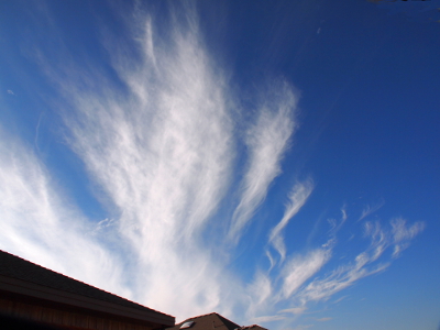 [Above the house tops are clouds which squiggle upward.]